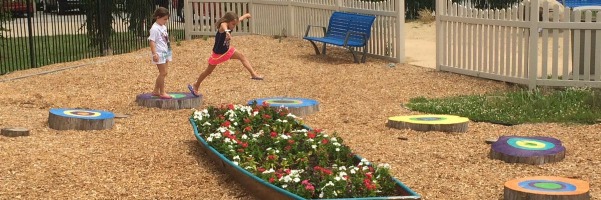 Girls jumping on painted stumps